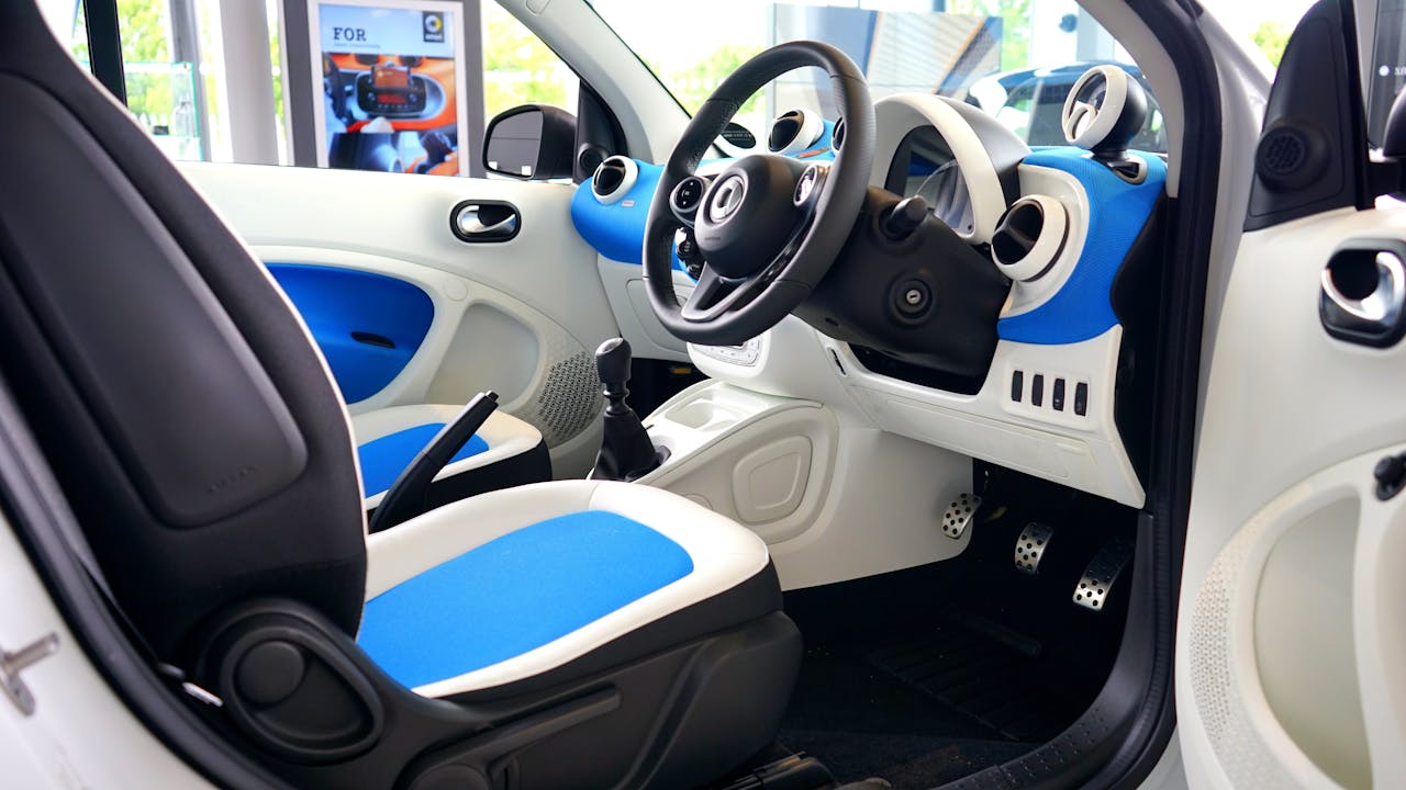 contact-img Explore the sleek blue and white interior of a luxury modern vehicle featuring advanced technology and style.