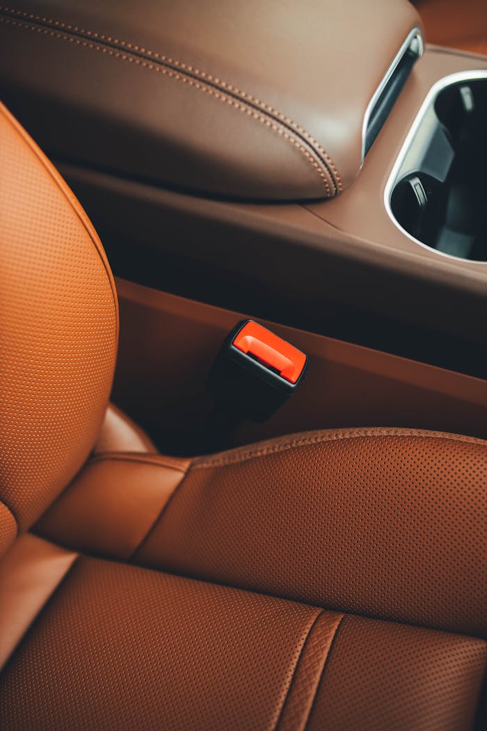 about-01 Close-up of a luxury car's brown leather interior showcasing sleek design and comfort.