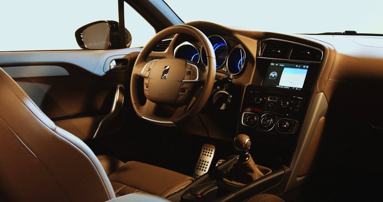 our-services-1 Interior view of a luxury car showcasing a leather seat and illuminated dashboard, featuring modern design elements.